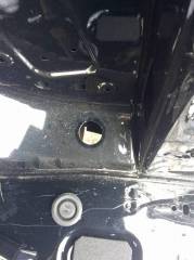 Passenger rear drain or potential wire pass-through (plug shown removed)